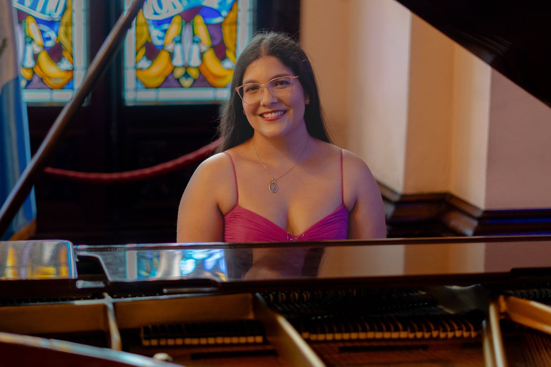 Virginia Villalobos sonriendo frente a un piano de cola